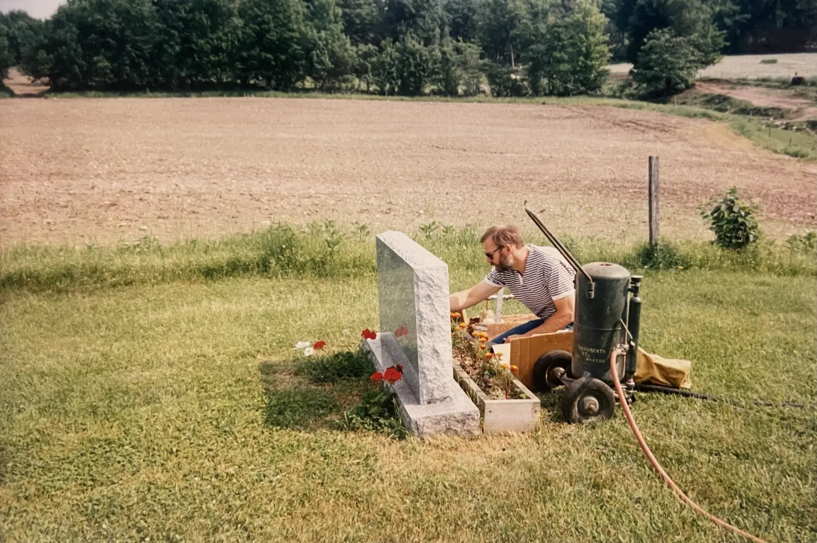 Jeff Bell Pignona setting up a sandblast on a stone in a rural Vermont cemetery