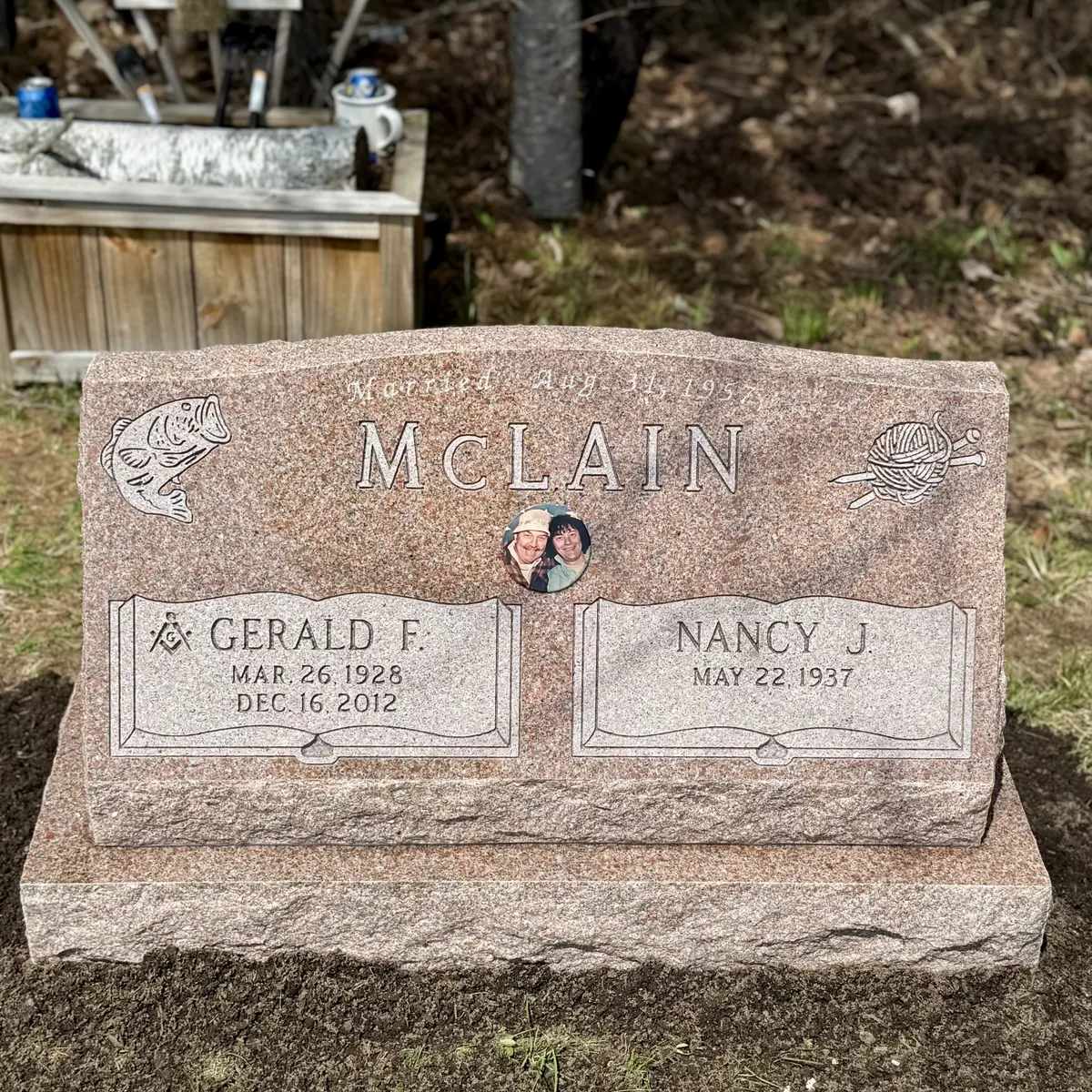 The McLain memorial — Mountain Rose slant with frosted-outline family name, steeled book name panels, sandblast corner designs, and a ceramic portrait