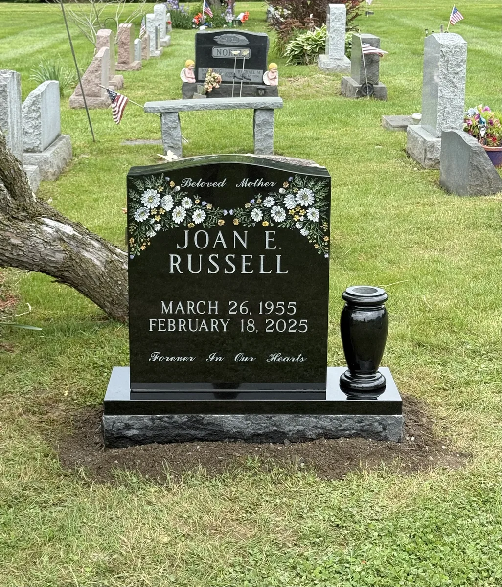 The Russell memorial — polished black granite upright with hand-etched floral design