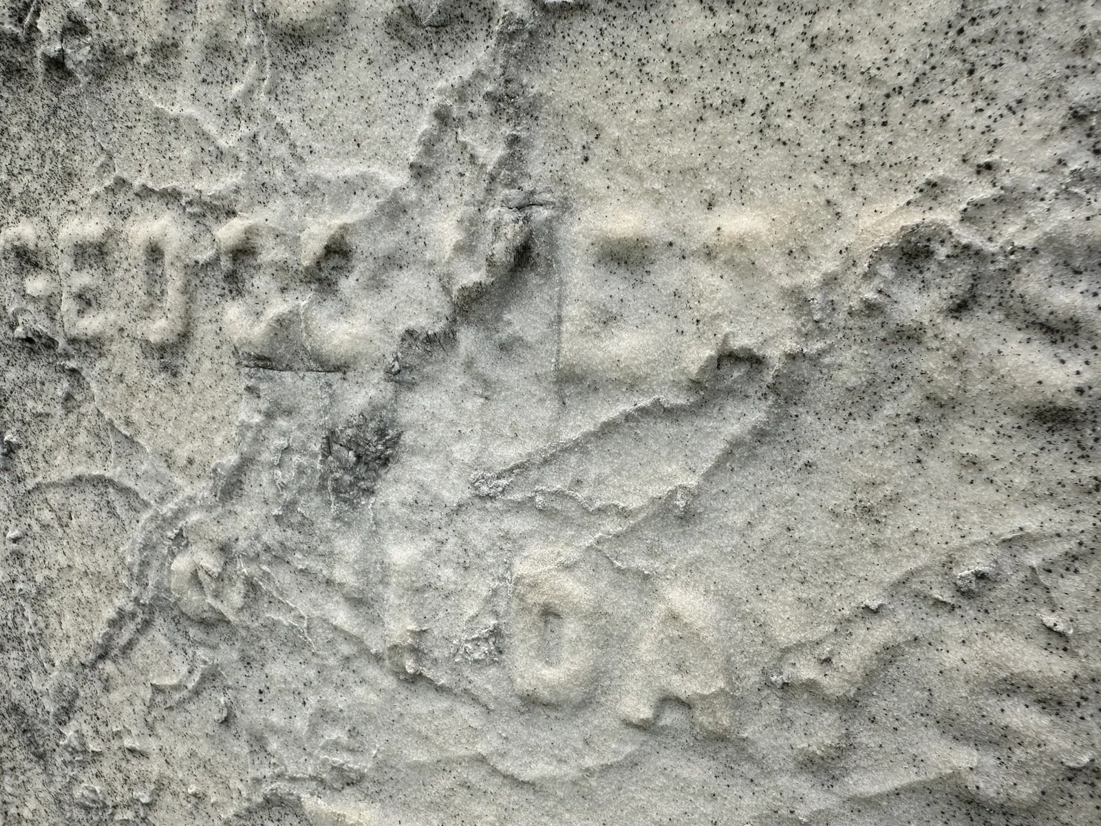 Close-up of severely sugared marble where most of the carved inscription has been lost to surface erosion