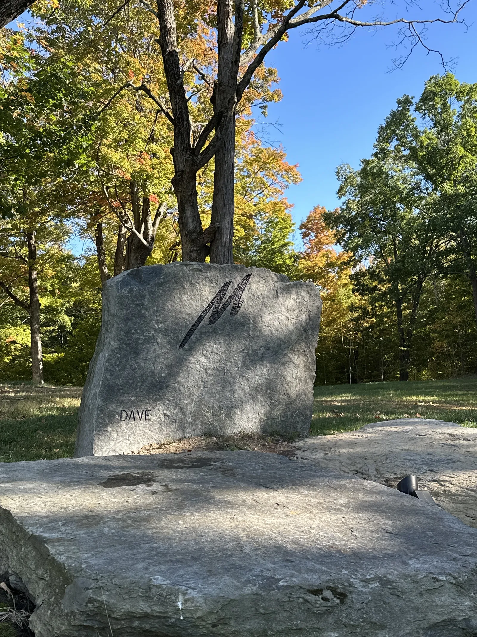 Custom boulder memorial with stylized monogram and name carved into a granite boulder