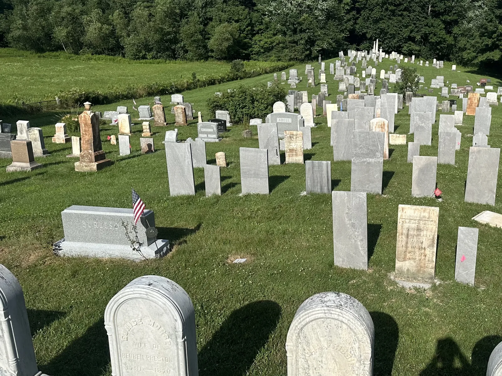 Cemetery-wide cleaning in progress on weathered marble headstones