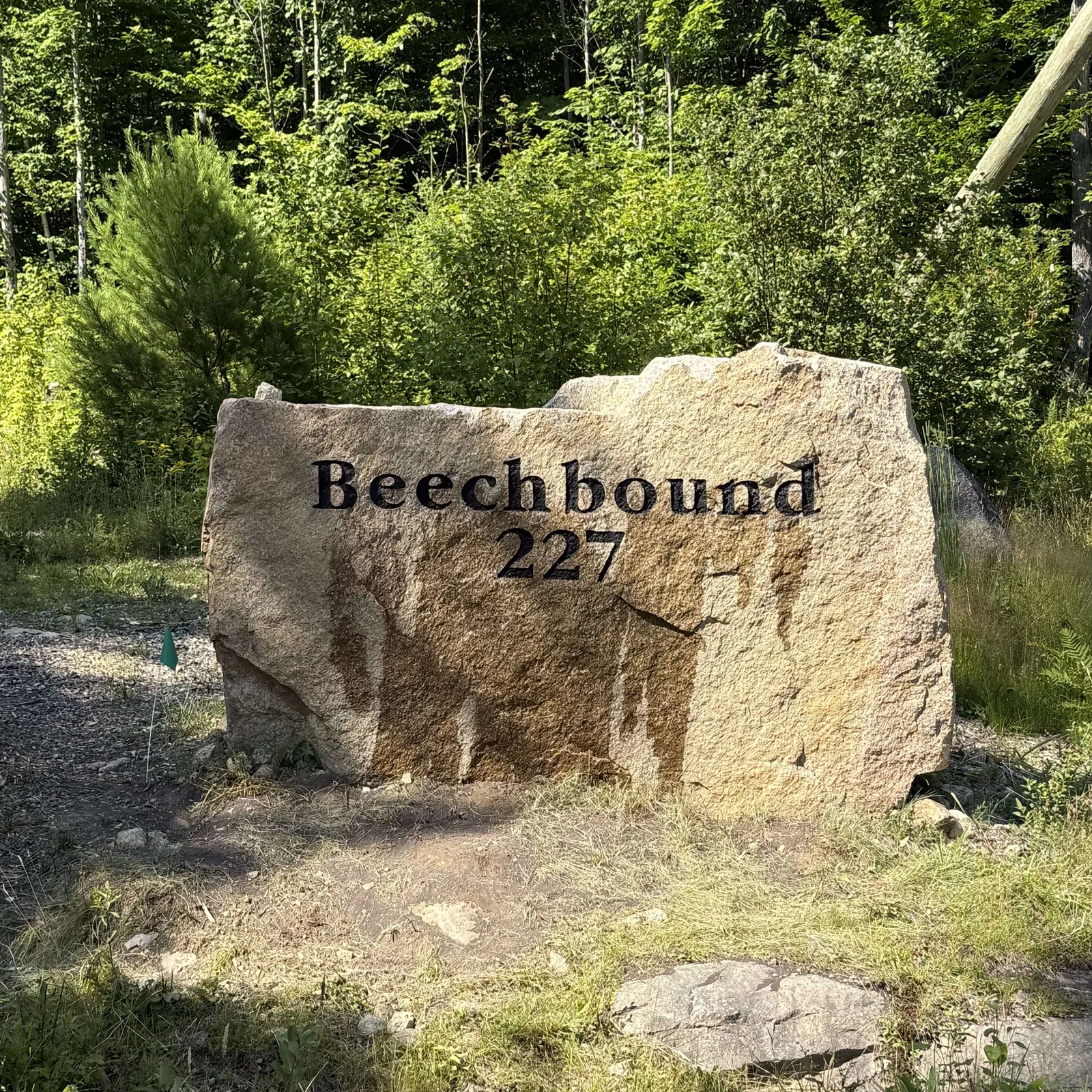 Property name and address carved into a granite boulder