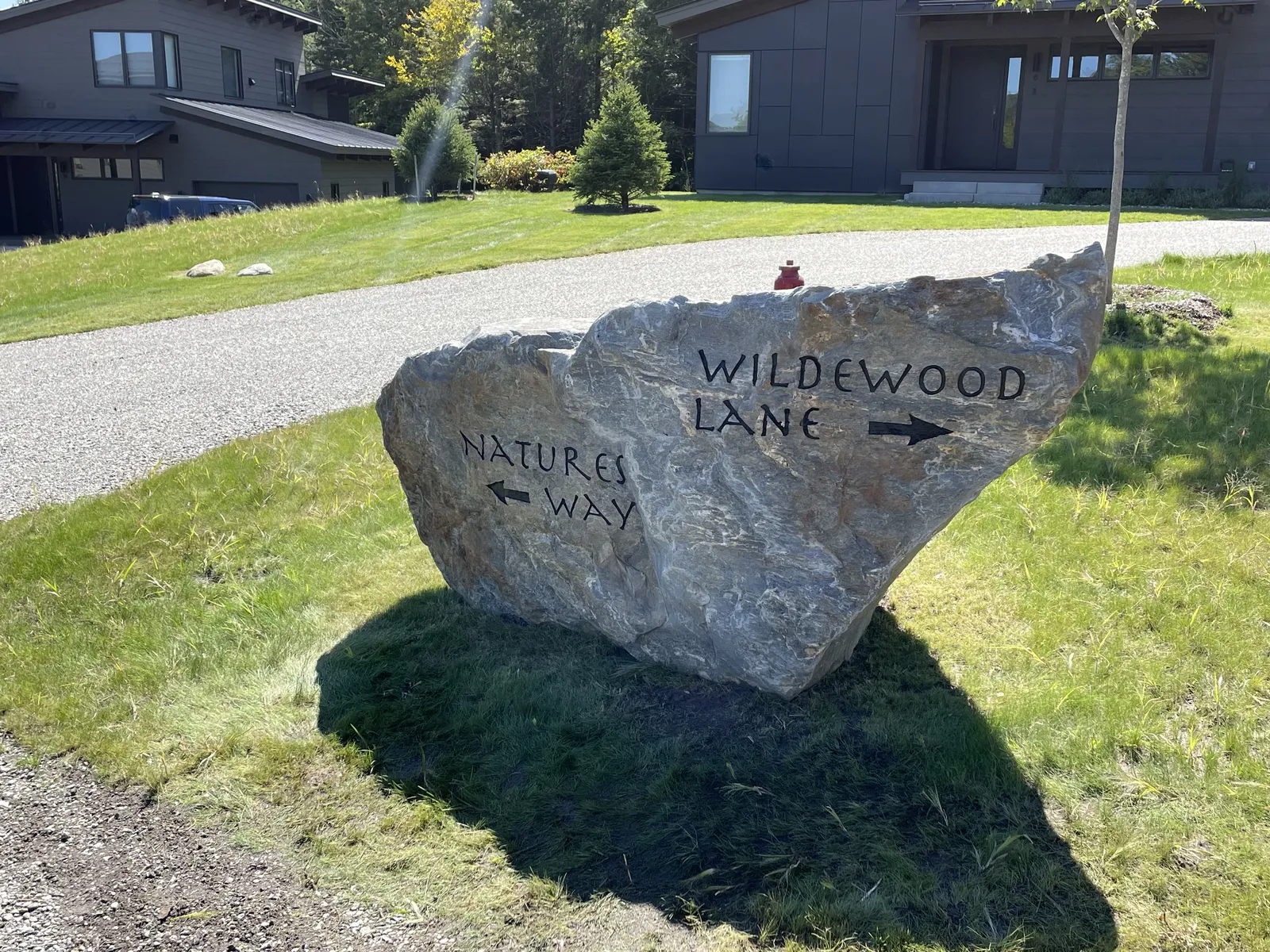 Two-arrow trail-marker boulder with custom street names